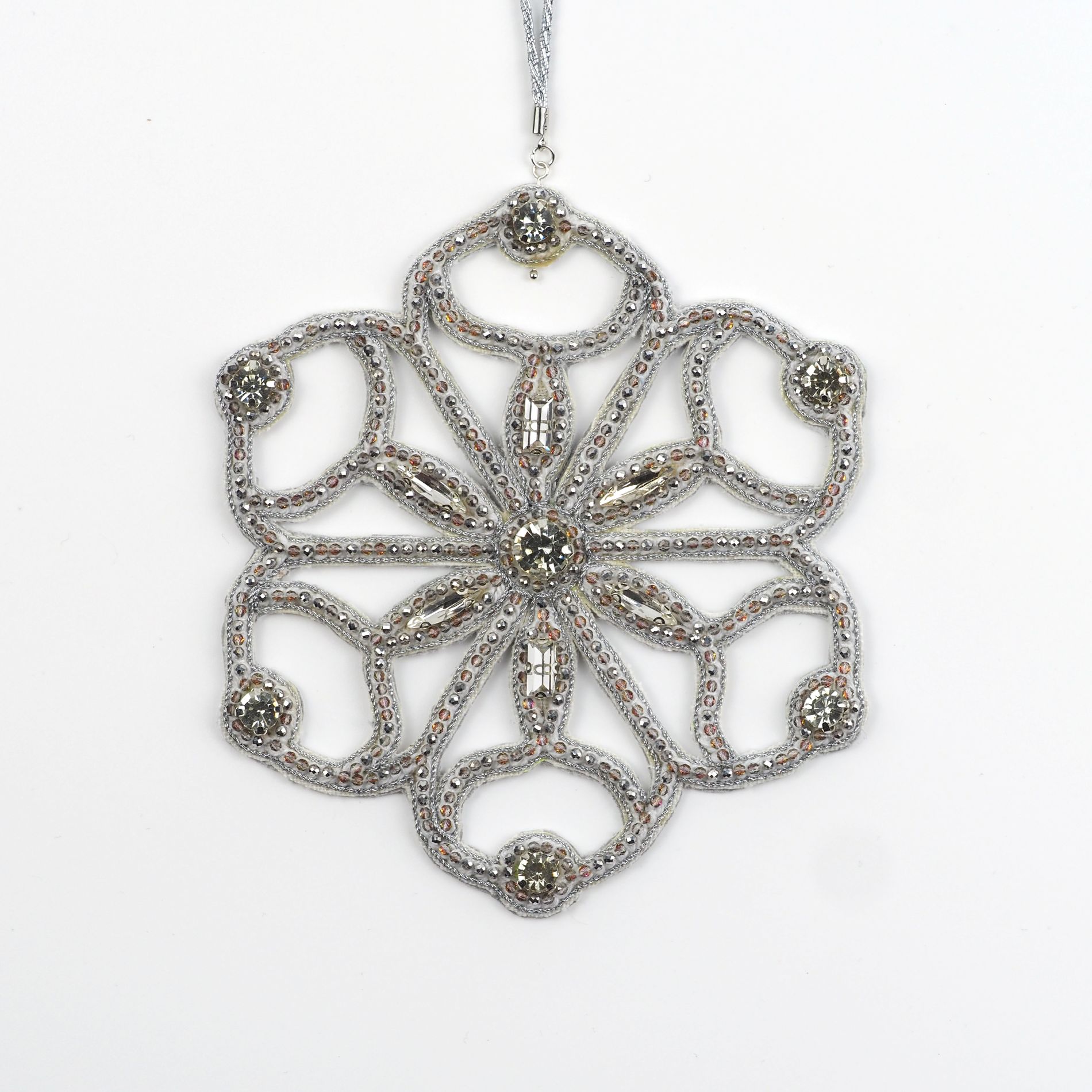 Close-up of the Jewels of Winter Six-Pointed Cut-Out Snowflake Ornament by Ksenia Semirova. Hand-embroidered with the pearl-setting technique using silver fire-polished glass beads and crystals, finished with a white leather back and silver hanging cord