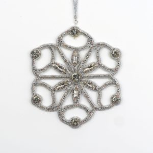 Close-up of the Jewels of Winter Six-Pointed Cut-Out Snowflake Ornament by Ksenia Semirova. Hand-embroidered with the pearl-setting technique using silver fire-polished glass beads and crystals, finished with a white leather back and silver hanging cord