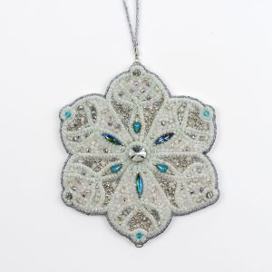 Full view of the Jewels of Winter Six-Pointed Snowflake Ornament by Ksenia Semirova. Hand-embroidered using the pearl-setting technique with white and silver beads, turquoise crystals, and a silver hanging cord.