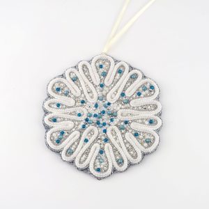 Hand-embroidered circular snowflake ornament from the Jewels of Winter series by Ksenia Semirova. Made with the pearl-setting technique using white, silver, and blue beads, finished with velvet backing and satin ribbon.