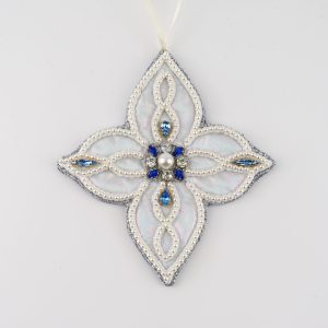 Hand-embroidered four-pointed snowflake ornament from the Jewels of Winter series by Ksenia Semirova. Made with the pearl-setting technique on iridescent faux leather, decorated with imitation pearls and blue vintage crystals.