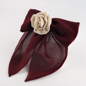Angled view of maroon chiffon bow hair clip with nude silk rose by ByRova, designed and handmade by Ksenia Semirova, showing volume and sheer chiffon