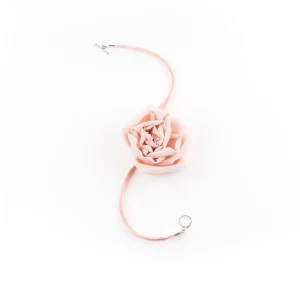 Flat lay of pink silk rose choker necklace with suede lace and toggle clasp, featuring a handmade chiffon flower