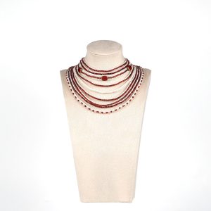 Handmade red and white multi-strand necklace with glass beads, mother of pearl beads, and larger gold-edged round beads, displayed on a mannequin bust